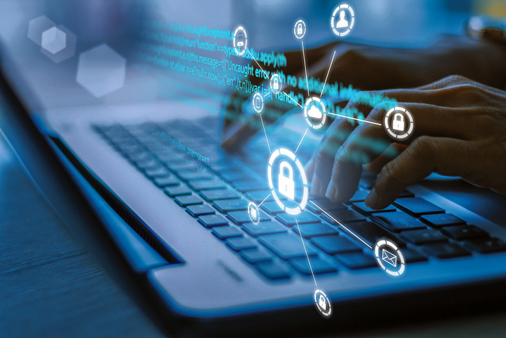 Business, technology, internet and networking concept. Young businesswoman working on his laptop in the office, select the icon security on the virtual display.